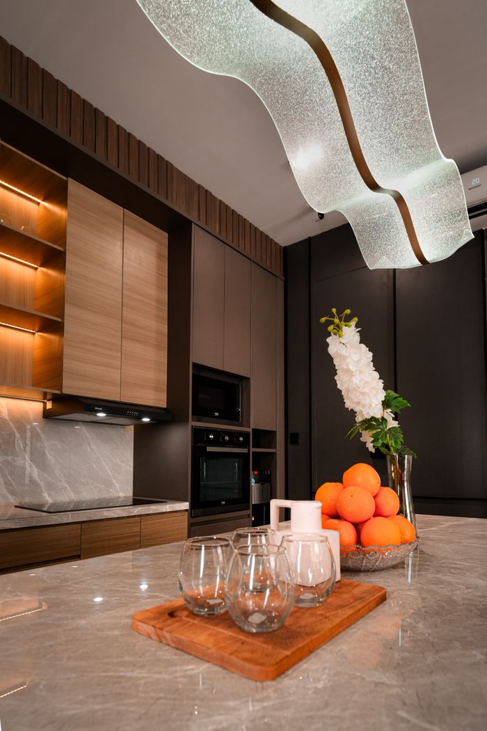 services-03 Elegant kitchen interior featuring a marble countertop, modern lighting, and a decorative fruit bowl.